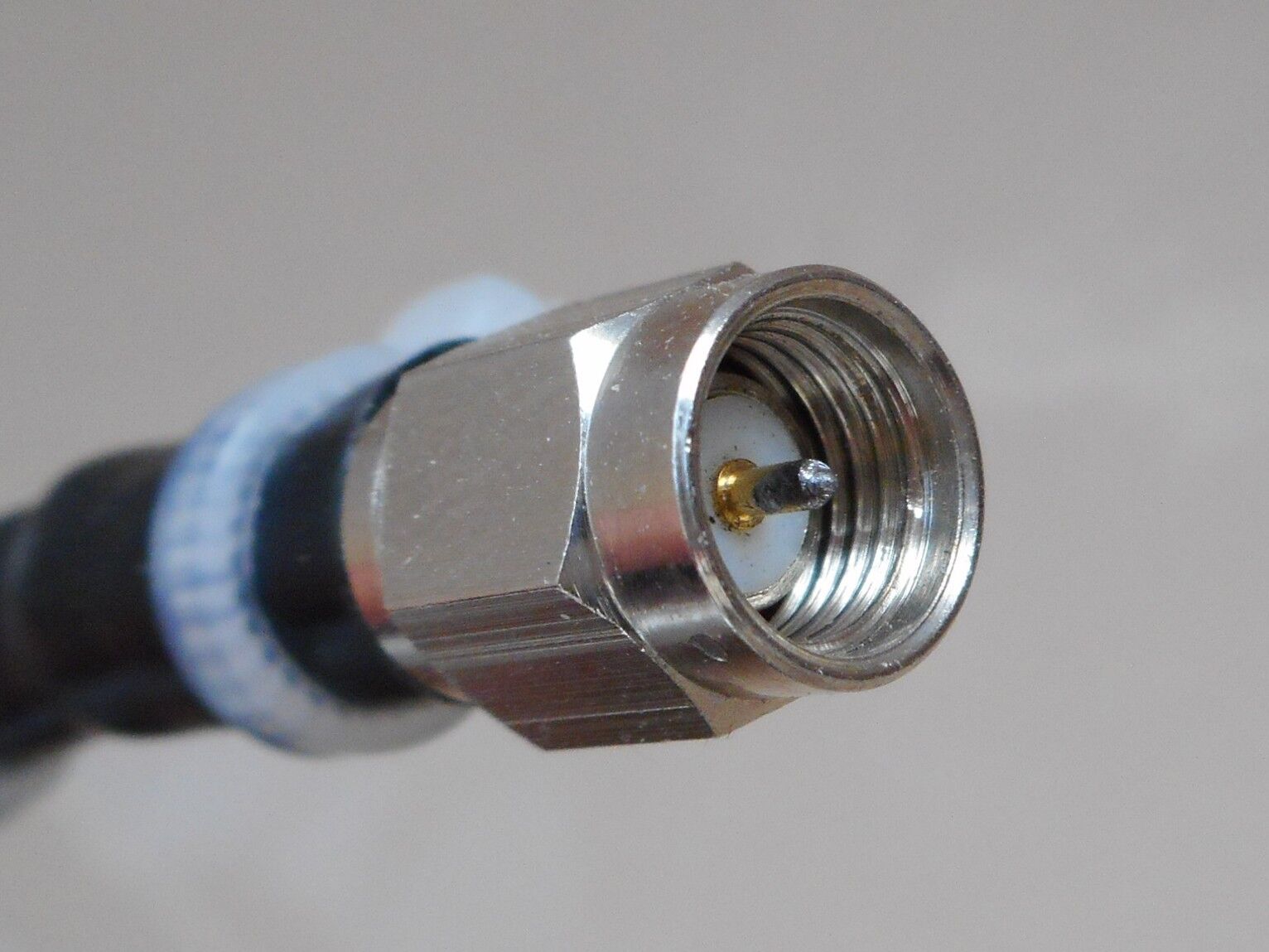 Macro photo of a male SMA coax connector showing the gold center pin